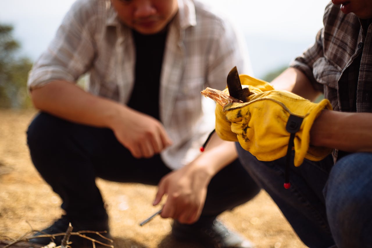 Two men in yellow gloves are kneeling down